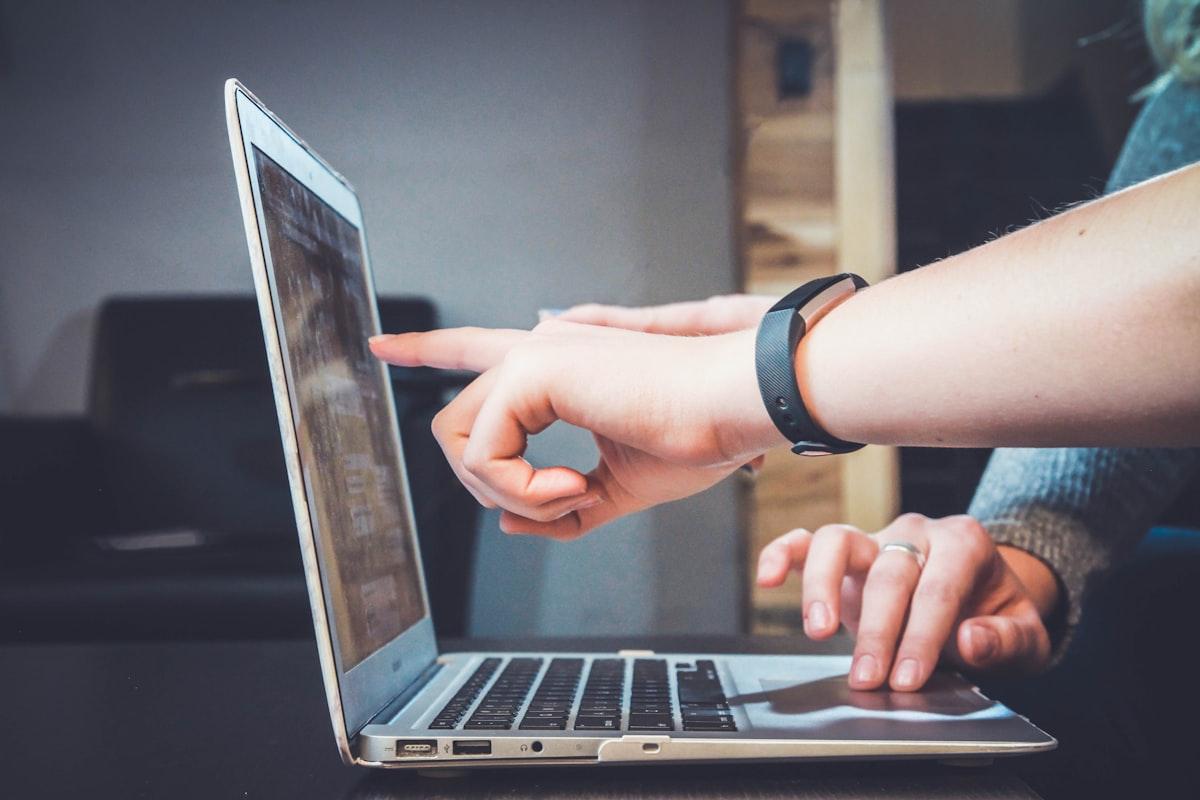 Close-up of hands typing on a laptop keyboard with a coffee mug nearby, focusing on AI flashcard generation and content creation.