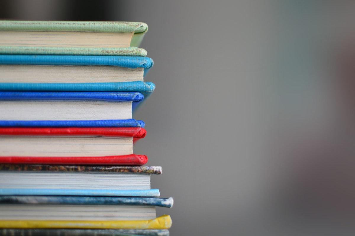 A beautiful aesthetic stack of academic library textbooks and learning materials, representing high-quality curriculum focus.