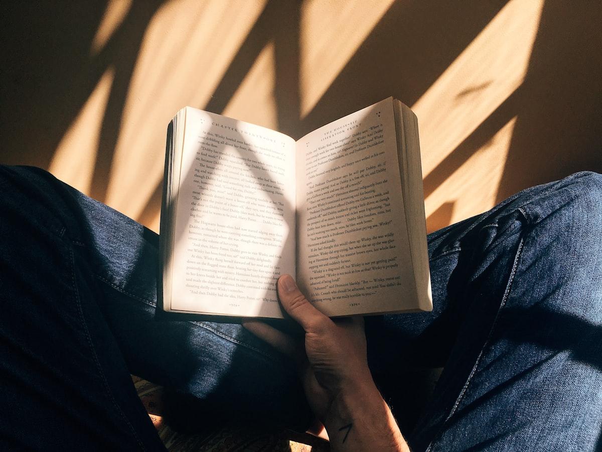 A student deeply engaged in reading an open textbook in a warm, quiet environment, representing intense focus on core high-yield subjects.